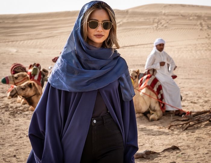 Jamie Chung in blue abaya and headscarf in the desert