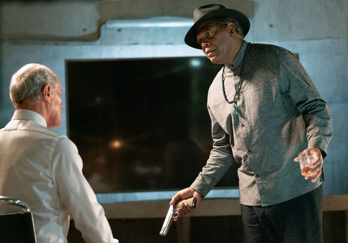 Samuel L. Jackson with gun and drink in The Protégé