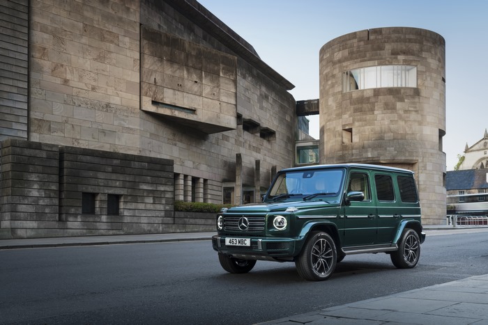 Green Mercedes-Benz G 400 d SUV by modern stone building