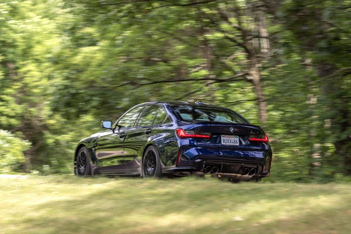Blue BMW M3 Competition G80 driving in nature