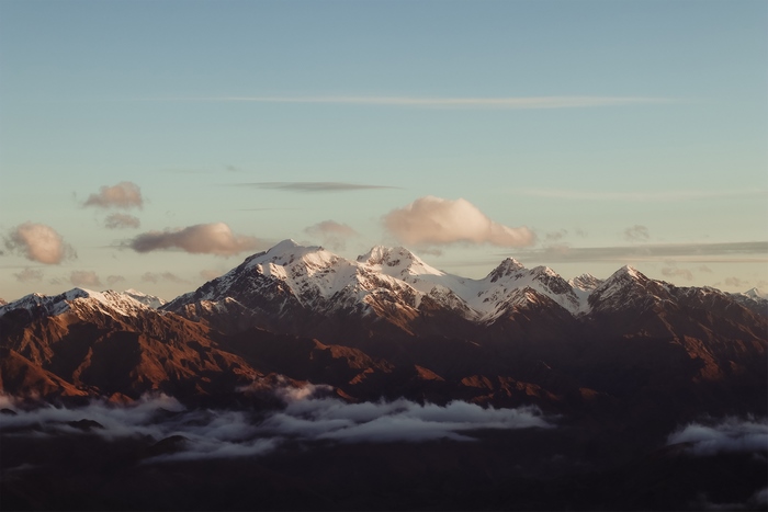 Snowy mountain peaks and clouds at sunrise