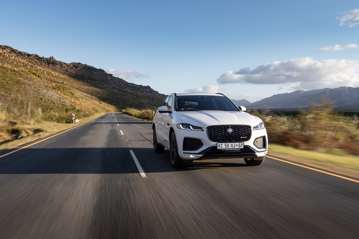 White Jaguar F-Pace SUV driving on a scenic road