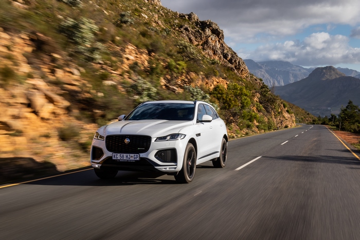 White Jaguar F-Pace SUV on a winding mountain road