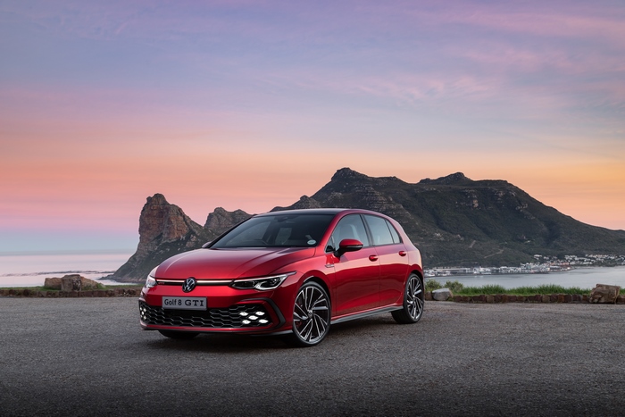 Red Volkswagen Golf 8 GTI at scenic coastal sunset