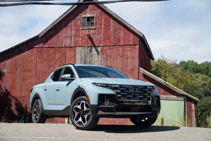 Hyundai Santa Cruz pickup truck in front of a red barn