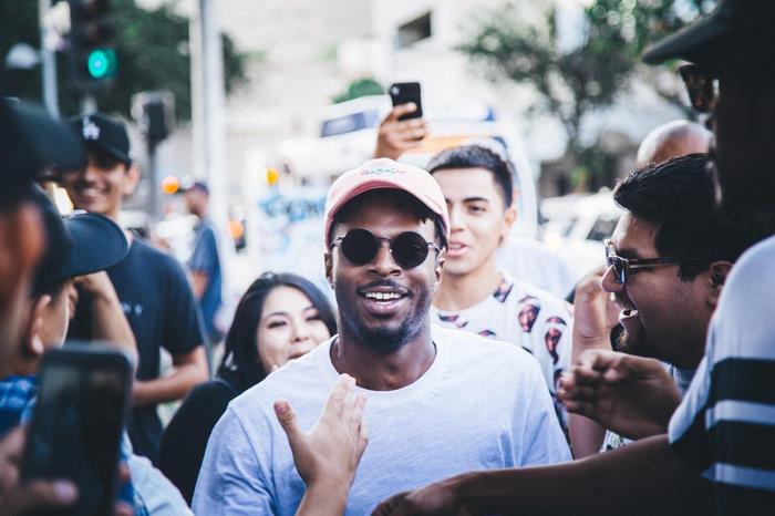 Isaiah Rashad smiling with fans outdoors