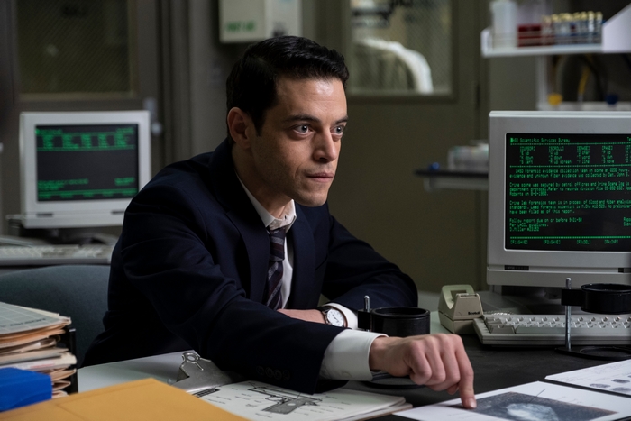 Rami Malek pointing at evidence in a lab