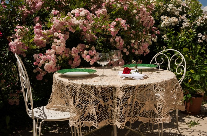 Restaurant table for two in a blooming rose garden