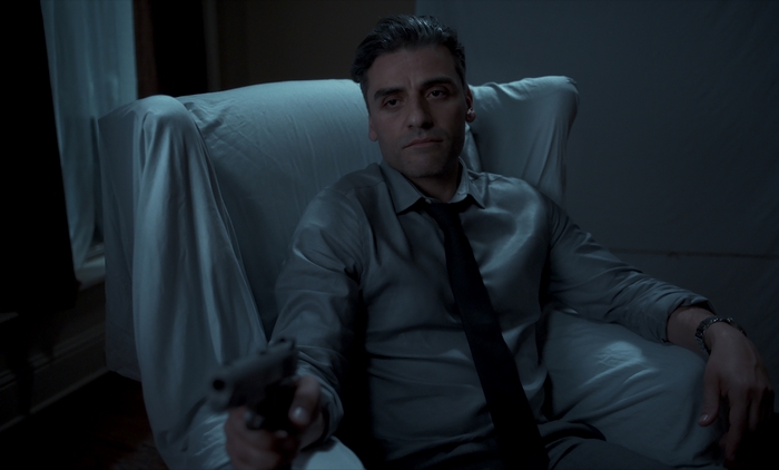 Oscar Isaac holding a gun in The Card Counter