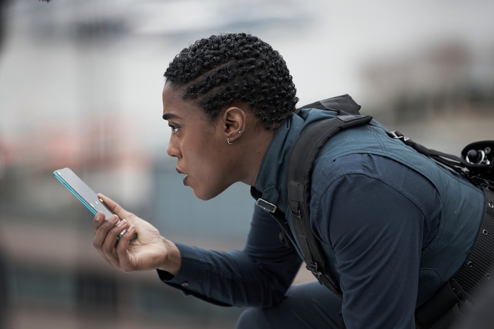 Lashana Lynch as Nomi focused on phone in No Time To Die