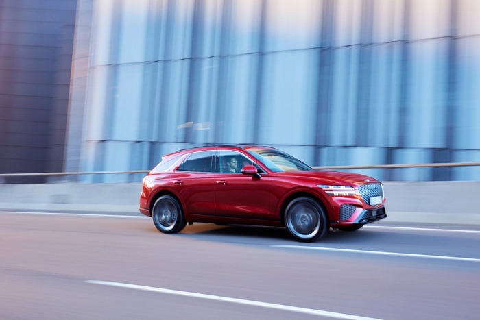 Red Genesis GV70 SUV in motion