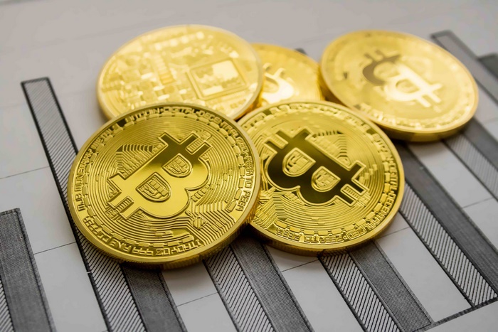 Golden Bitcoin coins on a financial chart