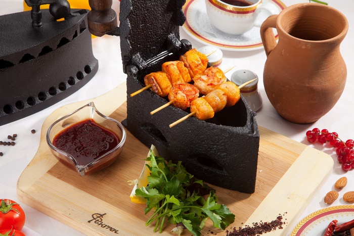 Grilled skewers served in a unique cast iron barbecue