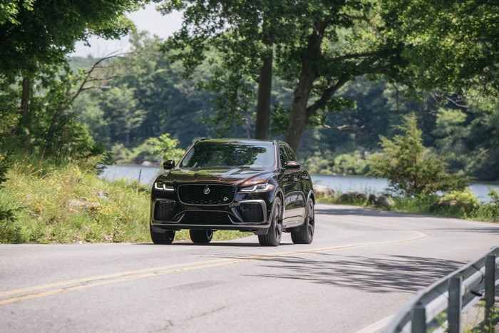 Brown Jaguar F-Pace SVR SUV on a scenic lakeside road