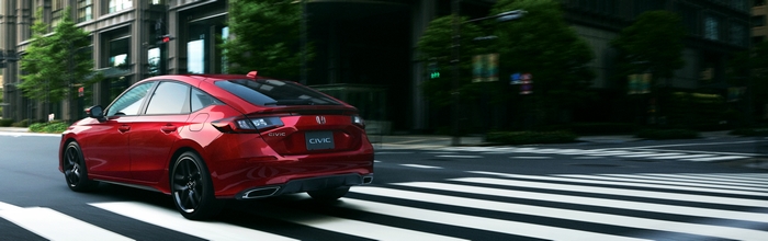 Red Honda Civic Hatchback Driving on City Street