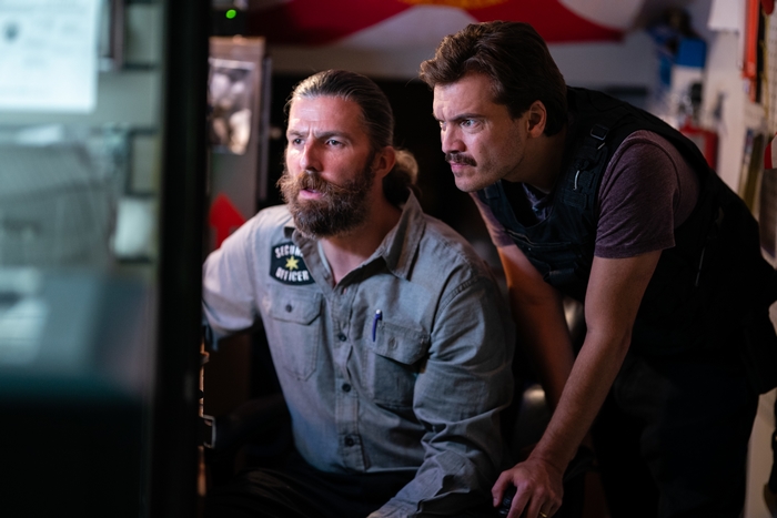 Emile Hirsch and security officer focused in Midnight In The Switchgrass