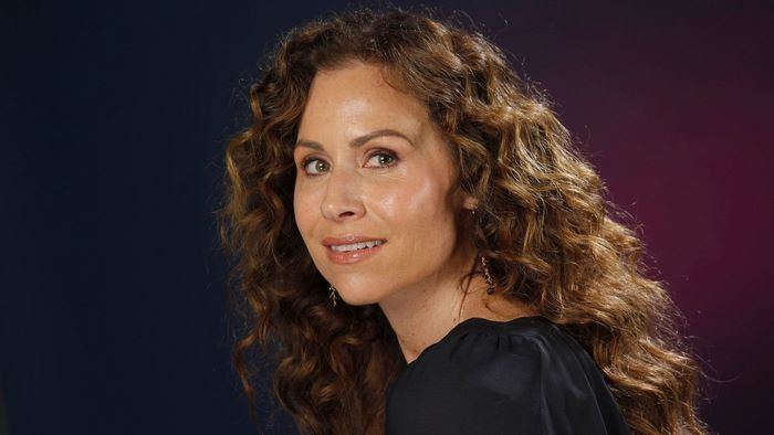 Minnie Driver smiling with curly hair