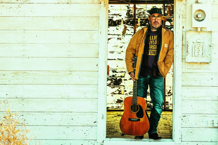 Aaron Lewis with acoustic guitar in doorway