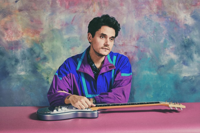 John Mayer in vibrant jacket with guitar