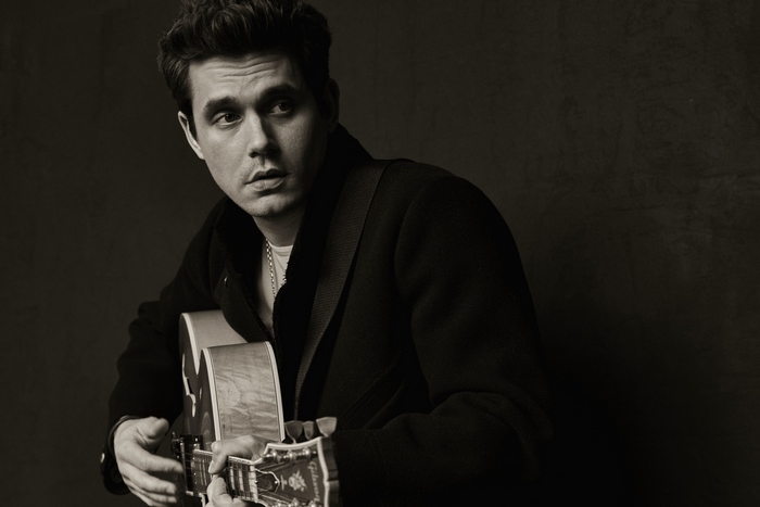John Mayer playing acoustic guitar in monochrome