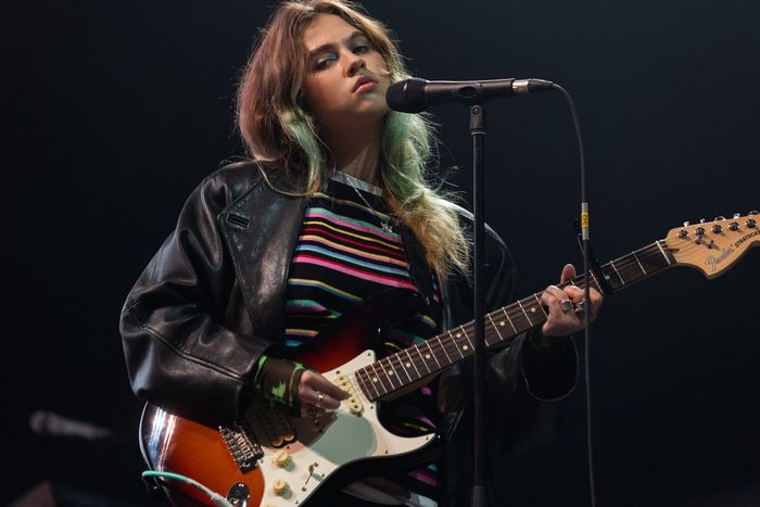 Clairo performing live with guitar and microphone