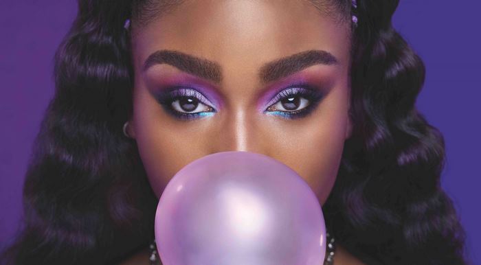 Normani with vibrant purple eye makeup and bubblegum