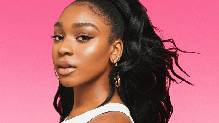 Normani with sleek high ponytail and gold chain earrings