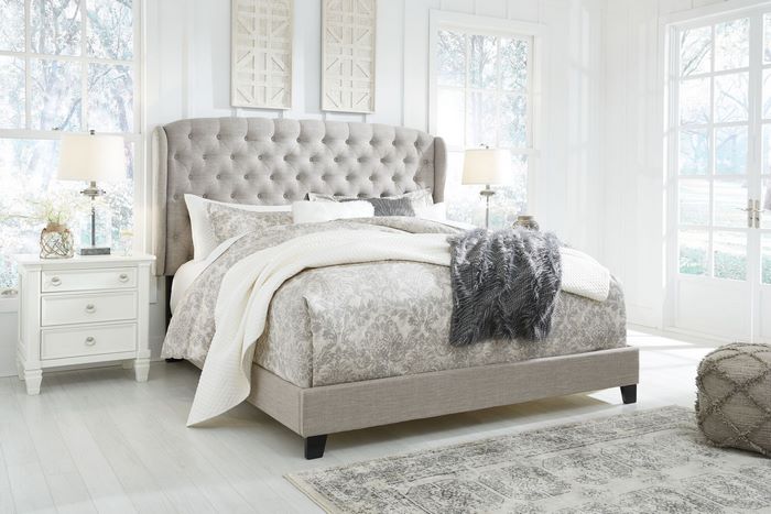 Bright bedroom with a grey tufted upholstered bed