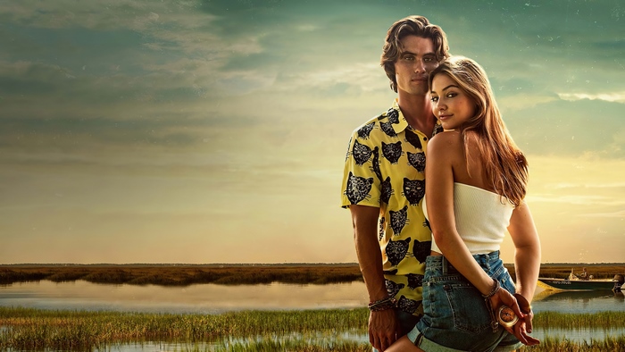 Madelyn Cline and Chase Stokes in a marsh