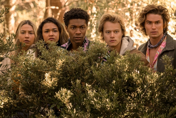 Outer Banks cast peeking from behind bushes