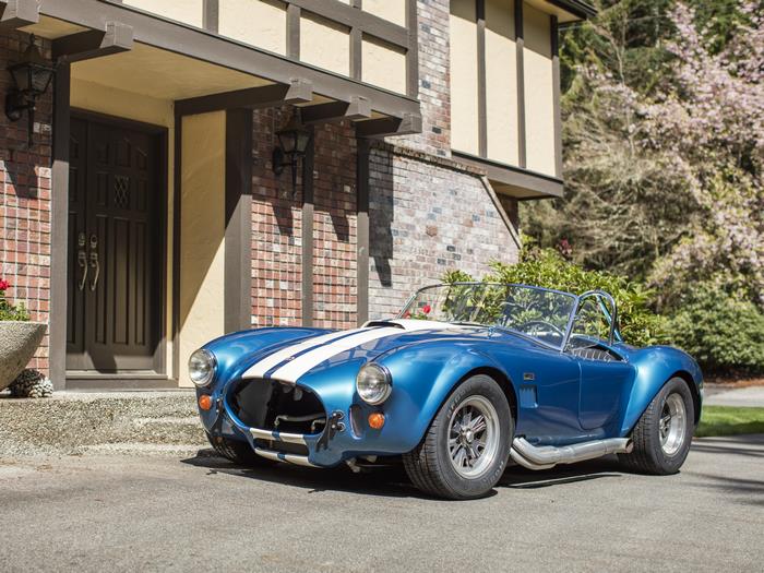 Blue 1966 Shelby Cobra 427 sport car by a house