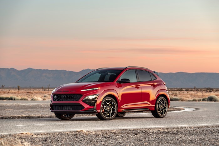 Red 2022 Hyundai Kona N SUV on desert road at sunset
