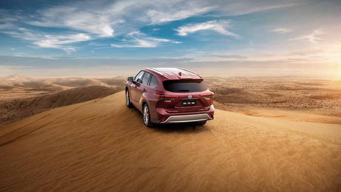 Red Toyota Highlander Hybrid SUV on desert dune
