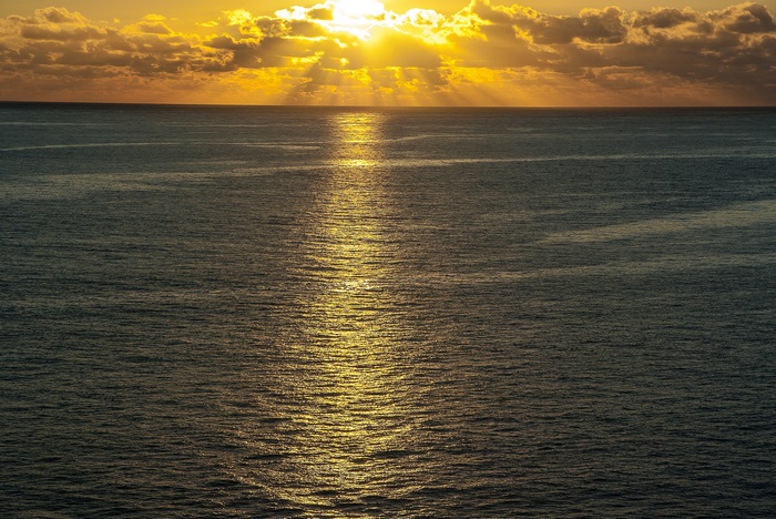 Ocean sunset with dramatic sun rays and golden glow