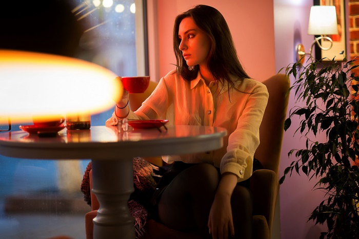 Beautiful model in a warm, moody cafe