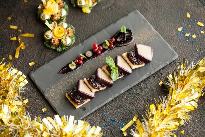 Festive berry dessert on slate with golden decorations