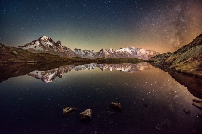 Milky Way and snowy mountains reflected in lake