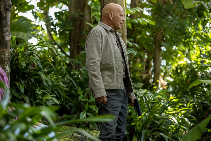 Bruce Willis holding a gun in the jungle for Out Of Death