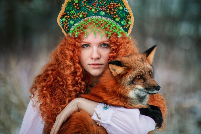 Redhead woman in traditional headdress with fox