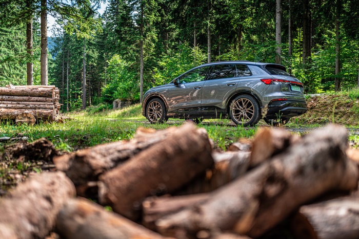 Audi Q4 e-tron SUV in forest with logs