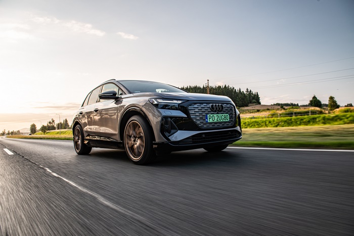 Audi Q4 e-tron SUV driving at sunset