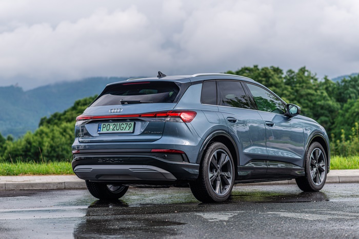 Blue Audi Q4 E-tron electric SUV on wet road