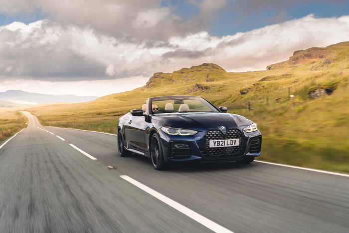 BMW M440i Cabriolet cruising through a hilly landscape