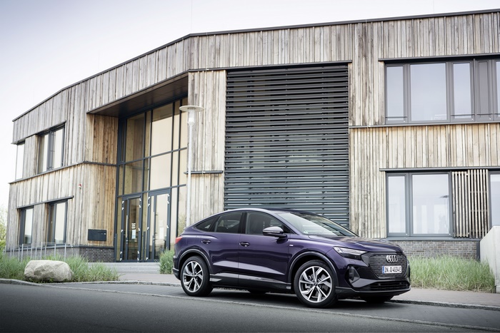 Purple Audi Q4 Sportback e-tron electric SUV by modern building