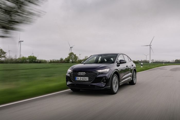 Audi Q4 Sportback e-tron Electric SUV driving past wind turbines