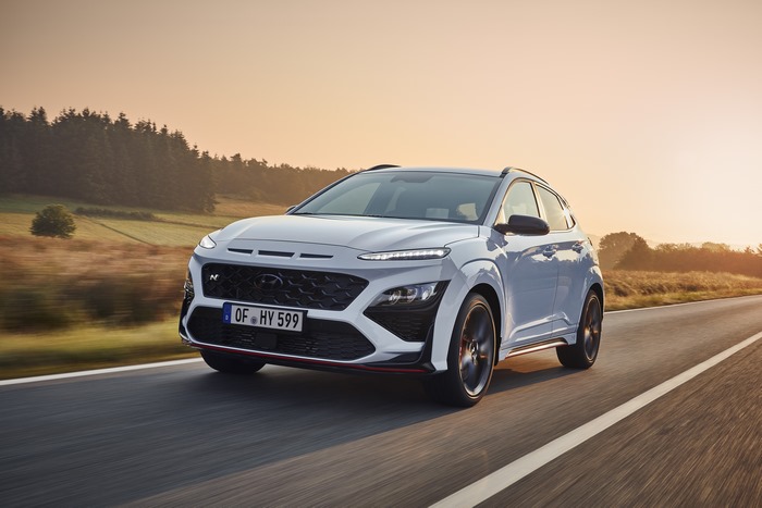 White Hyundai Kona N SUV driving at sunset