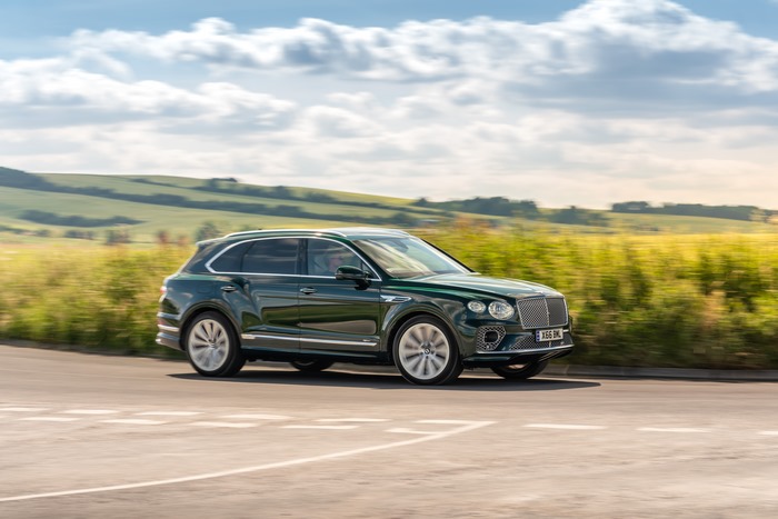 Green Bentley Bentayga SUV driving through countryside