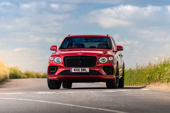 Red Bentley Bentayga Hybrid SUV on road