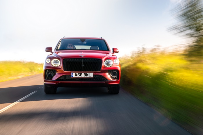 Red Bentley Bentayga Hybrid SUV in motion