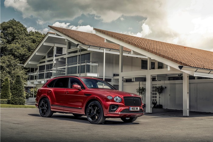Red Bentley Bentayga Hybrid SUV at a modern house